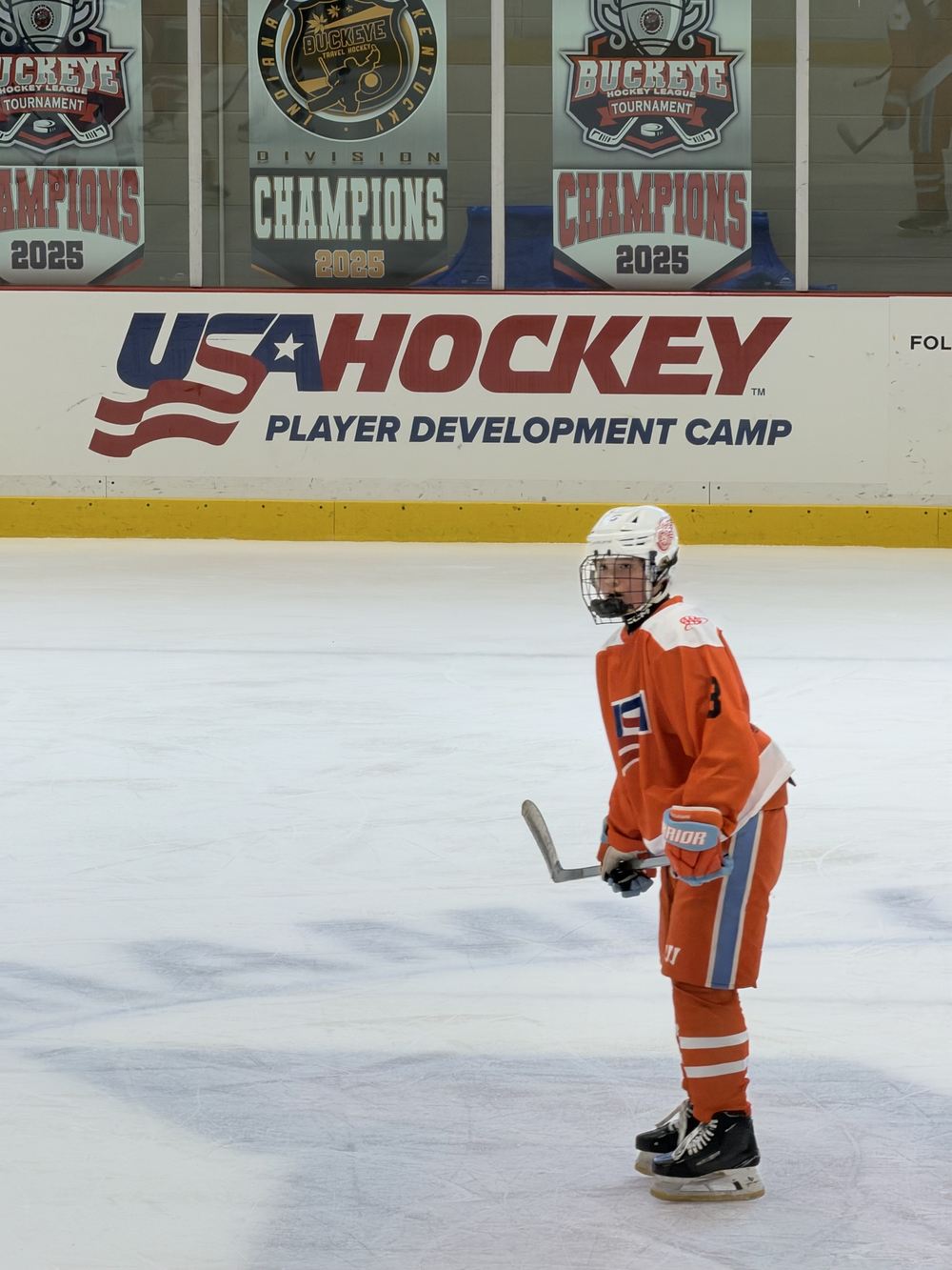 Cameron Cadena in her number 3 camp jersey beneath the USA Hockey Player Development Camp signage